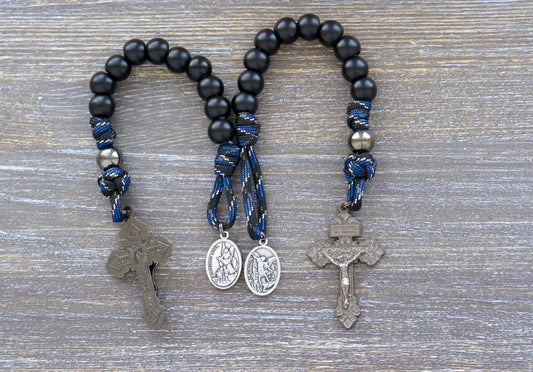 Thin Blue Line Pocket Rosary: Black/blue camo paracord with gunmetal and matte black acrylic beads, featuring a St. Michael medal and gunmetal crucifix.