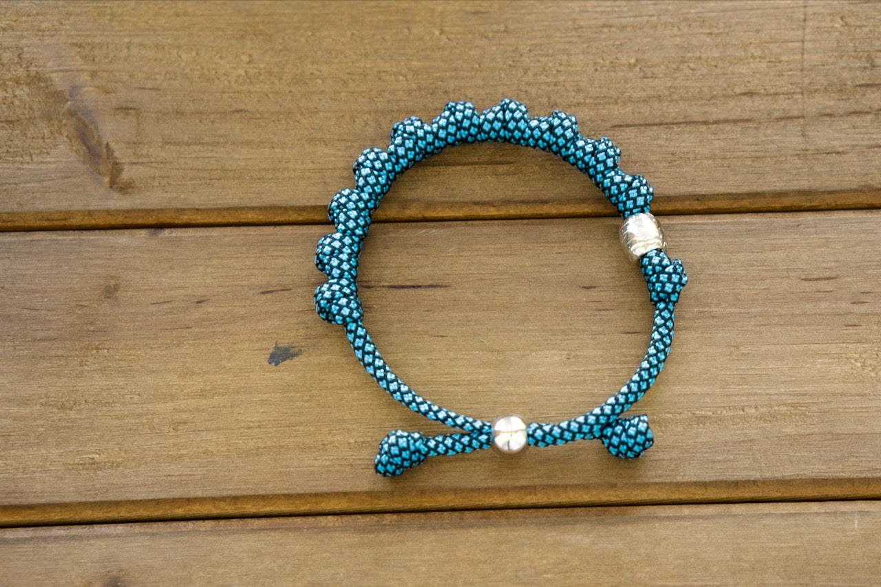 Embrace modern Catholic aesthetics with the Turquoise & Silver Rosary Bracelet from Sanctus Servo. This captivating rosary bracelet features a durable paracord design, perfect for strengthening your faith journey. Shop now!