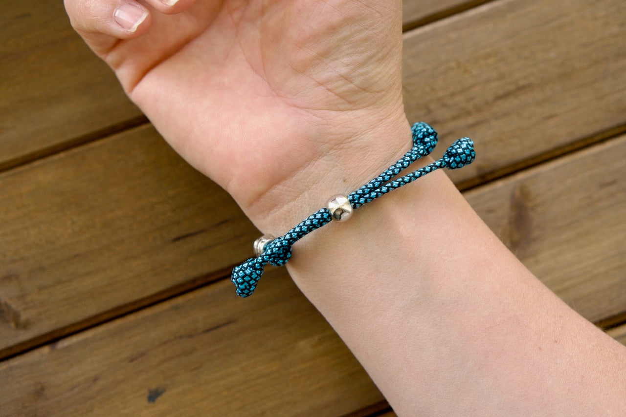 Turquoise & Silver Rosary Bracelet from Sanctus Servo - A captivating fusion of modern aesthetics and traditional Catholicism, perfect for your faith journey. Unbreakable paracord rosary bracelet with premium materials ensures lasting durability and spiritual strength. Shop our collection for the entire family!