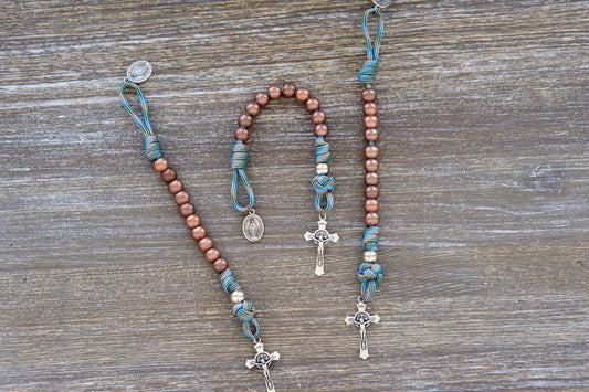 Bright light blue and copper paracord rosary with silver and acrylic beads, tiny Miraculous Medal, and St. Benedict crucifix – durable, faith-filled for kids.