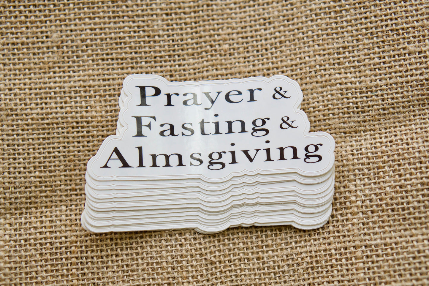 Strengthen your faith with Prayer, Fasting, Almsgiving - Vinyl Sticker by Sanctus Servo. This 4" x 1.75" motivational sticker is perfect for laptops, water bottles, and more, reminding you to deepen your spiritual journey and support those in need.