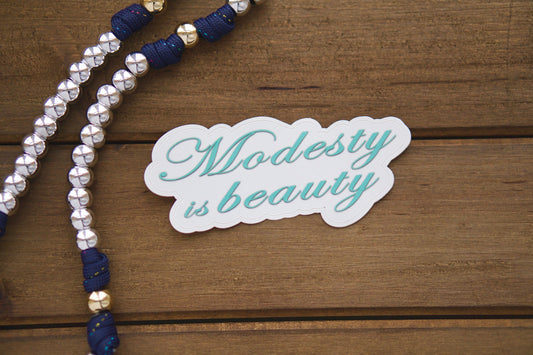 Modesty is Beauty - Spread the message of true beauty through modesty with this 4" x 2" vinyl sticker, perfect for laptops, water bottles, notebooks, and more. Pairs well with our rosaries and great as a stocking stuffer.