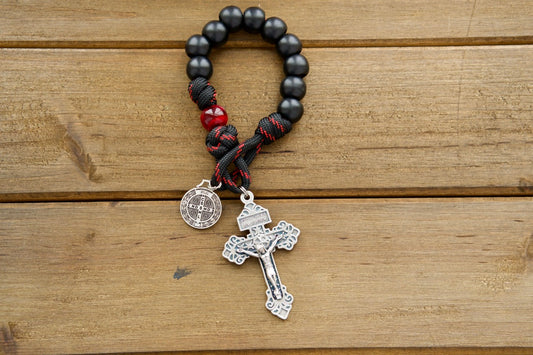 The Blood of Christ - Pocket Paracord Rosary with silver crucifix, St. Benedict medal, and black/red beads for portable Catholic devotion.