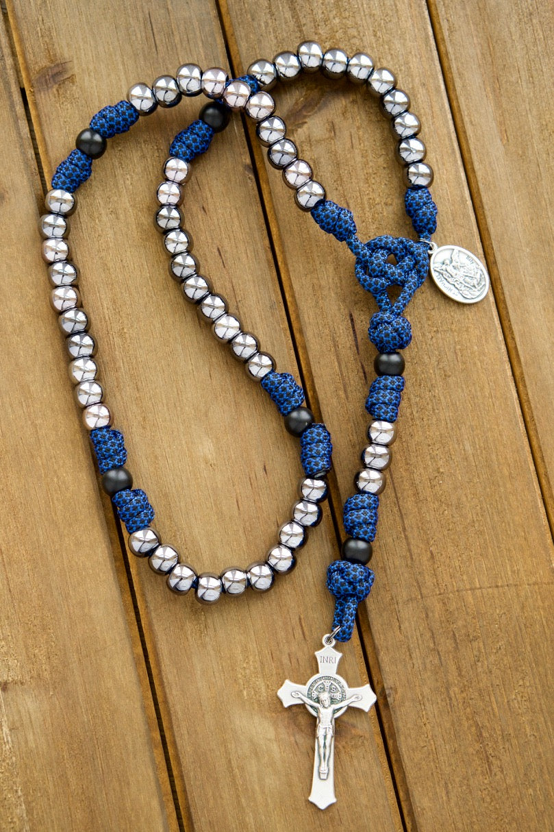 Introducing our Kids Blue and Gunmetal - 5 Decade Paracord Rosary, a premium unbreakable paracord rosary designed with younger Catholics in mind. This spiritual weapon features a blue rope with 10mm gunmetal beads and a St. Benedict Crucifix, perfect for boys ready to fight the good battle!