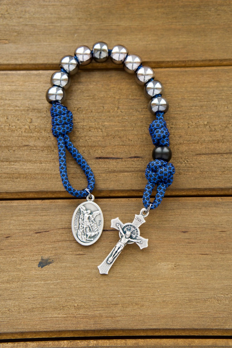 Blue and Gunmetal - Single Decade Paracord Rosary: A powerful prayer companion for boys, featuring resilient blue paracord rope, sturdy gunmetal-colored beads, St. Benedict Crucifix, Devotional Medal with St. Michael and Guardian Angel, and an overall length of 9 inches.