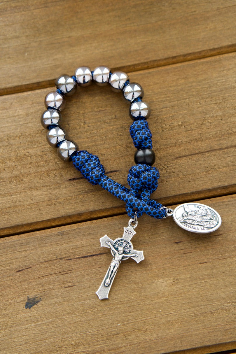 Striking blue and gunmetal single decade paracord rosary with 10mm beads, St. Benedict Crucifix, Devotional Medal featuring St. Michael and Guardian Angel, and an overall length of approximately 9 inches for spiritual protection and battle readiness.