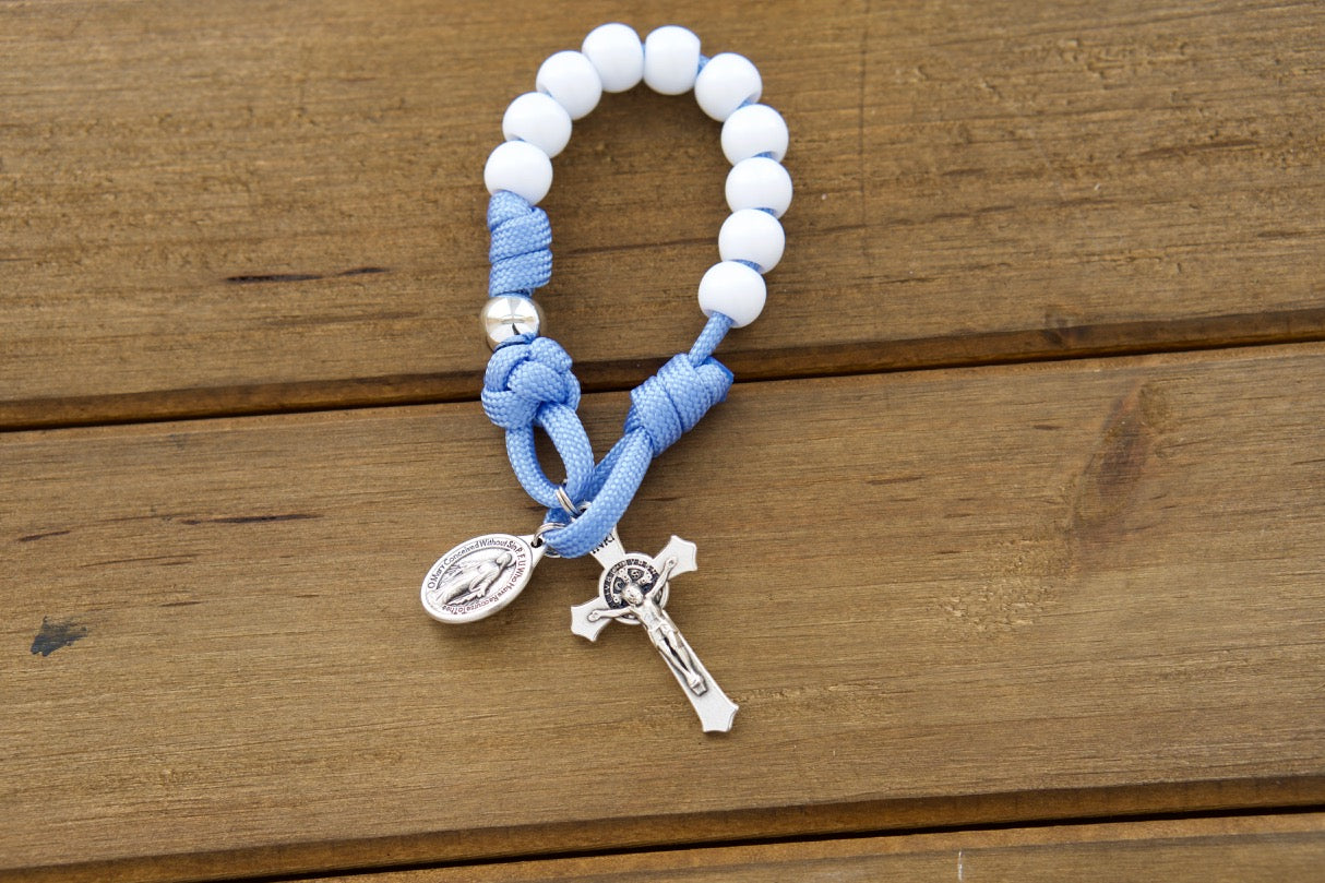Bright blue and white pocket paracord rosary with white Hail Mary and silver Our Father beads, designed for kids to pray with ease and joy.
