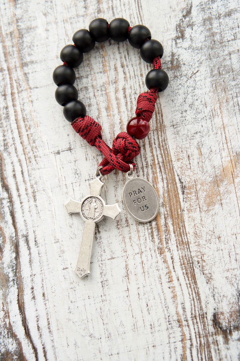 Deep maroon red paracord rosary with matte black beads and St. Benedict crucifix, perfect for boys or men preparing to receive the Sacrament of Confirmation. Durable 550 paracord, red enamel Holy Spirit devotional medal, and a 2" St. Benedict crucifix for strength and protection.