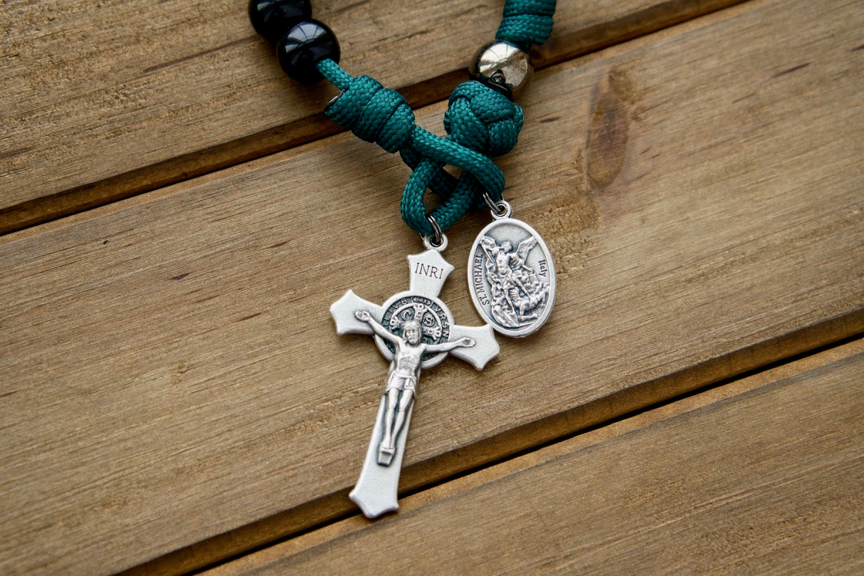 Dark Night of the Soul - 1 Decade Paracord Rosary (alt text): A durable, compact, and stylish paracord rosary for prayer on-the-go, featuring St. Michael, Guardian Angel, and St. Benedict Crucifix medals in dark green rope with black and gunmetal accents.
