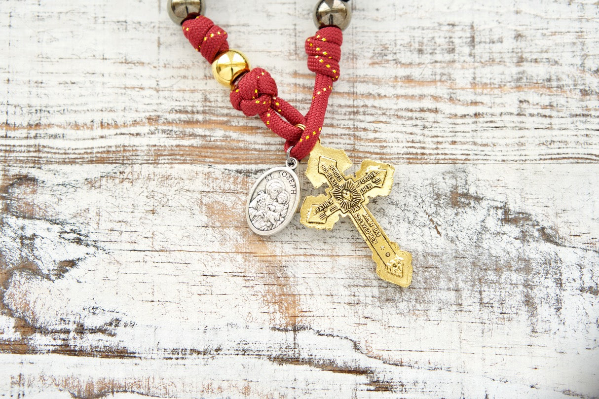 The Holy Family - 1 Decade Paracord Rosary, featuring a royal red, gold, and gunmetal design with an antique gold Pardon crucifix and a double-sided Holy Family/St. Joseph medal. Perfect for kids or adults, durable and unbreakable, handmade by a devout Catholic family.