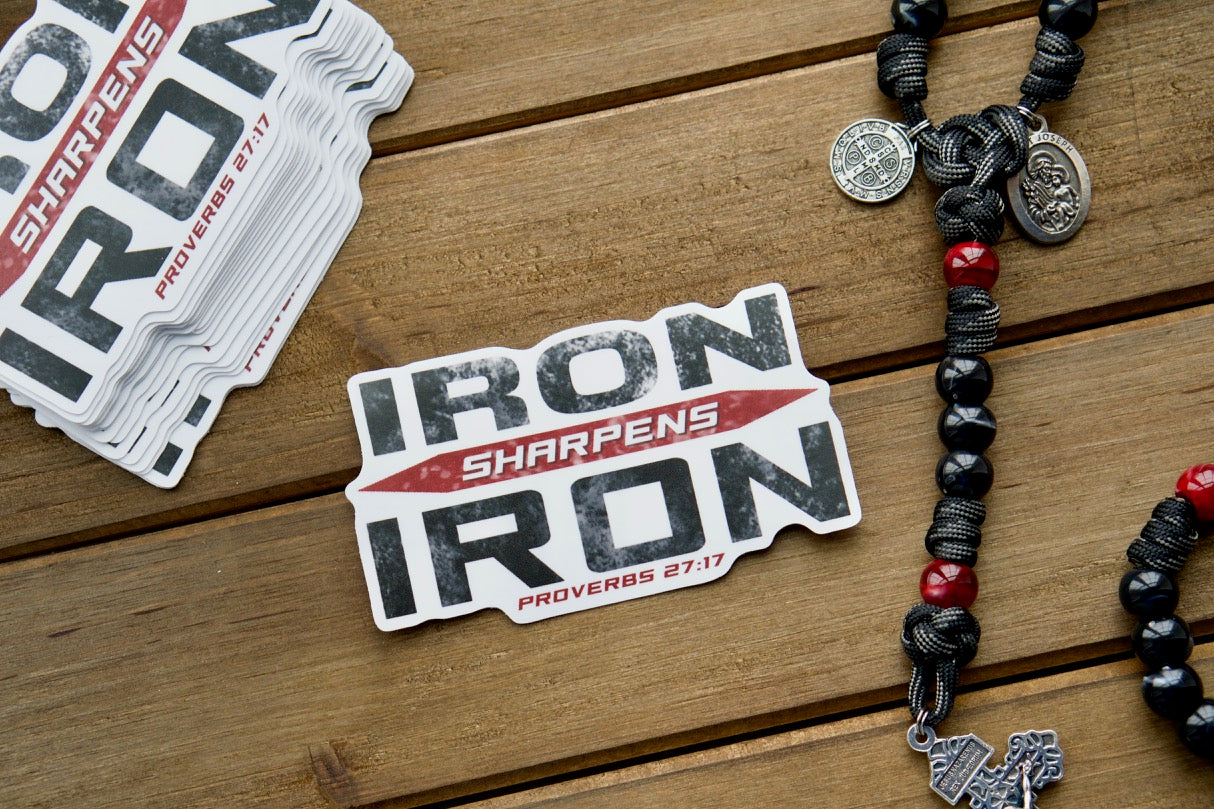 Iron Sharpens Iron (Proverbs 27:17) - Vinyl Sticker: A powerful reminder of our call to unity in the fight against evil. This waterproof, dishwasher and microwave-safe sticker measures 4" x 2.25" and is perfect for pairing with a Sanctus Servo rosary to spread the faith.