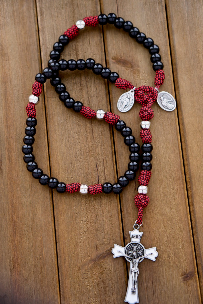 Handmade 5 decade paracord rosary in red, white, and black design honoring St. Maximilian Kolbe's double crown with a large enamel St. Benedict Crucifix and Miraculous Medal devotional. Durable and unbreakable for strong prayer support, designed for kids and adults alike.