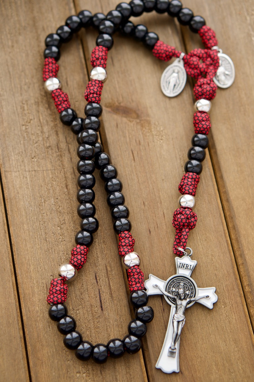 Militia Immaculatae - St. Maximilian Kolbe Red, White, and Black Signature 5 Decade Paracord Rosary. Handcrafted premium paracord rosary featuring enamel St. Benedict Crucifix, Miraculous Medal, and St. Kolbe medal. Durable, unbreakable design tested with kids in mind. Perfect for prayer and spiritual warfare.