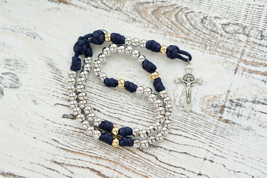 Dark blue paracord rosary with silver Hail Mary beads and gold Our Father beads, adorned with a St. Benedict Crucifix and Miraculous Medal, perfect for spiritual strength and prayer.