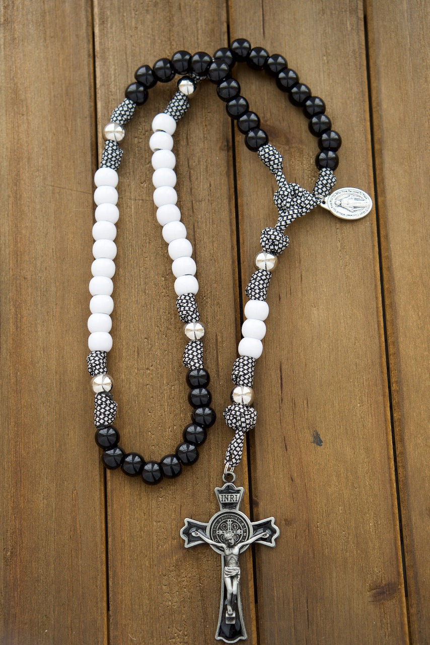 Two beautiful 5 decade paracord rosaries in black and white, symbolizing unity and commitment for a Catholic couple's prayer life. Handmade by a small Catholic family of 6, featuring durable paracord 550 rope, St. Benedict crucifixes, and Miraculous Medals.