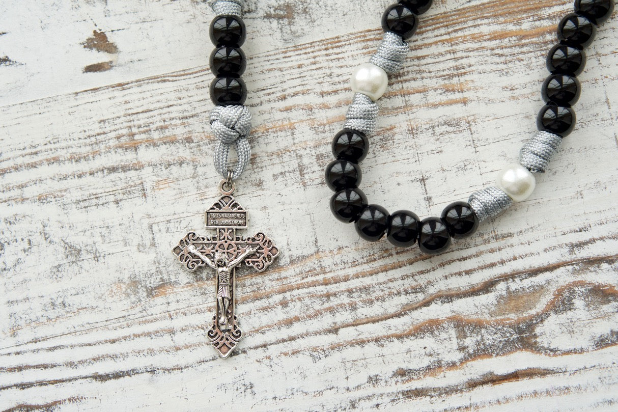 Mater Dolorosa - Our Lady of Sorrows - 7 Sorrows Paracord Rosary, featuring black, grey, and white colors and a 2" silver Pardon Crucifix. Perfect spiritual weapon for prayer and durability on life's battles.