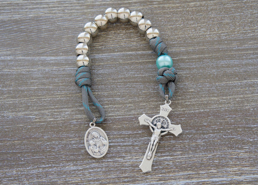 St. Anne's Intercession Pocket Paracord Rosary with gray-blue cord, silver Hail Mary beads, sky blue Our Father beads, and St. Anne medal.