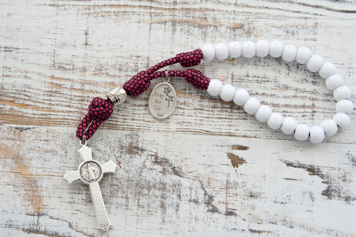 Unique St. Thérèse Paracord Chaplet with 24 white beads, pink paracord, St. Thérèse medal, and 2" St. Benedict crucifix. Durable Catholic sacramental for deepening devotion to the Little Flower.
