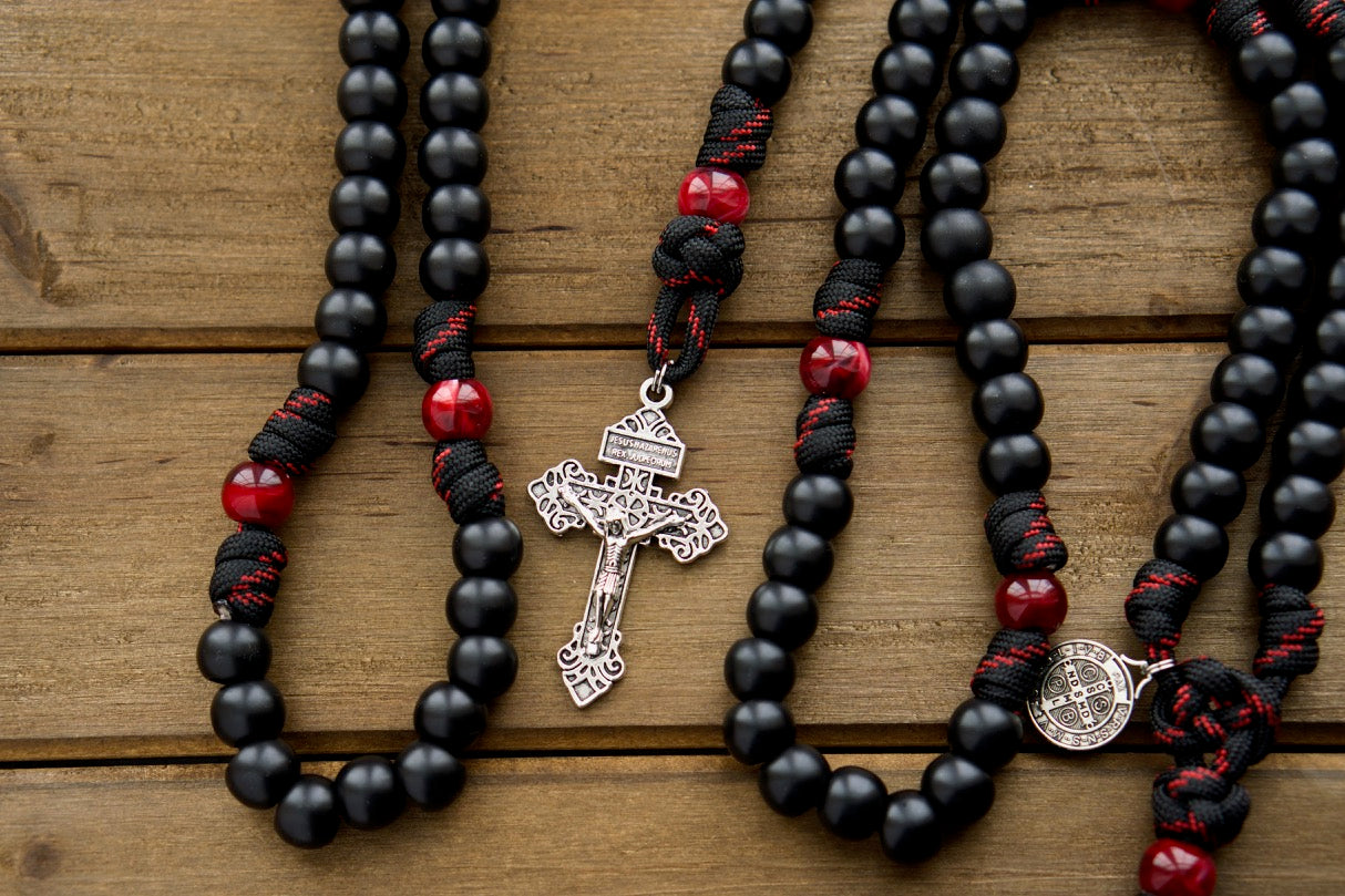 The Blood of Christ - 5 Decade Paracord Rosary, a powerful symbol of faith and devotion, featuring a silver pardon crucifix, St. Benedict medal, black and maroon/red beads, and strong paracord construction for daily use and special occasions. A must-have Catholic gift!