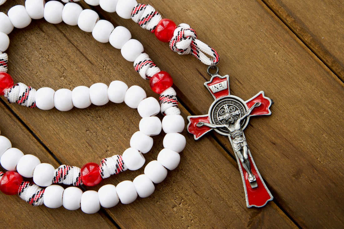 Paracord rosary with white and red beads and a red enamel St. Benedict crucifix