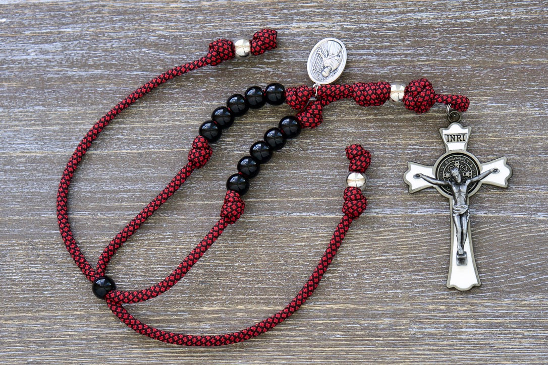 Rearview Mirror Rosary featuring red Paracord with black acrylic beads, silver Our Father bead, large white enamel St. Benedict Crucifix, and St. Kolbe devotional medal.