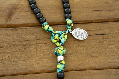 The Adventure Awaits - Green, Black and Silver - 5 Decade Paracord Rosary, a durable and stylish Catholic gift for young boys. This premium paracord rosary is expertly crafted with high-quality lime green, blue, and black camo paracord, designed to withstand the rigors of outdoor adventures while keeping their faith close at hand.