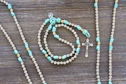 Teal blue paracord rosary with silver & gold 10mm beads, St. Benedict crucifix, and Miraculous Medal devotional.