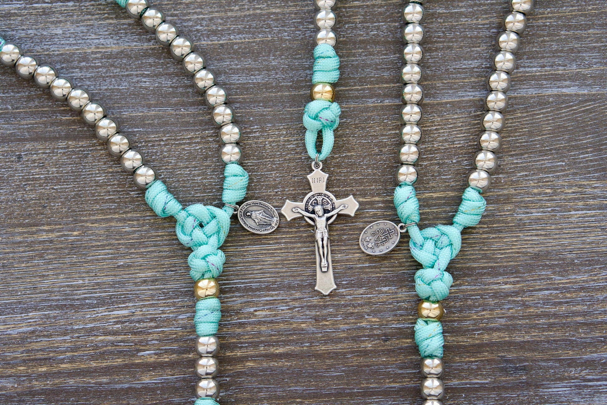 August Queen of the Heavens - Kid's 5 Decade Paracord Rosary with teal blue paracord, rainbow ribbon accents, silver and gold acrylic beads, Miraculous Medal, and St. Benedict Crucifix.