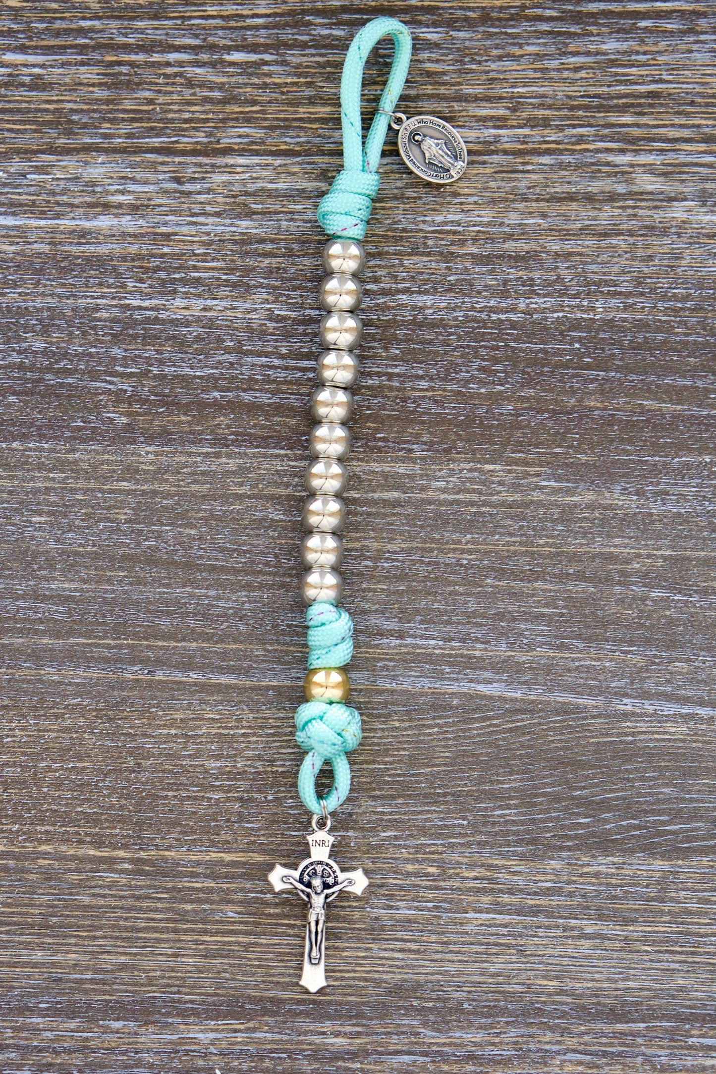 Kids Pocket Paracord Rosary featuring 10mm acrylic beads, a rose gold Our Father bead, silver Hail Mary beads, a petite St. Benedict crucifix and Miraculous Medal, designed for small hands and portability.