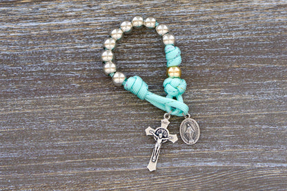 Compact paracord rosary with 10mm acrylic beads, silver Hail Marys, rose gold Our Father bead, St. Benedict crucifix, and Miraculous Medal for children.  Sized for portability and everyday prayer.