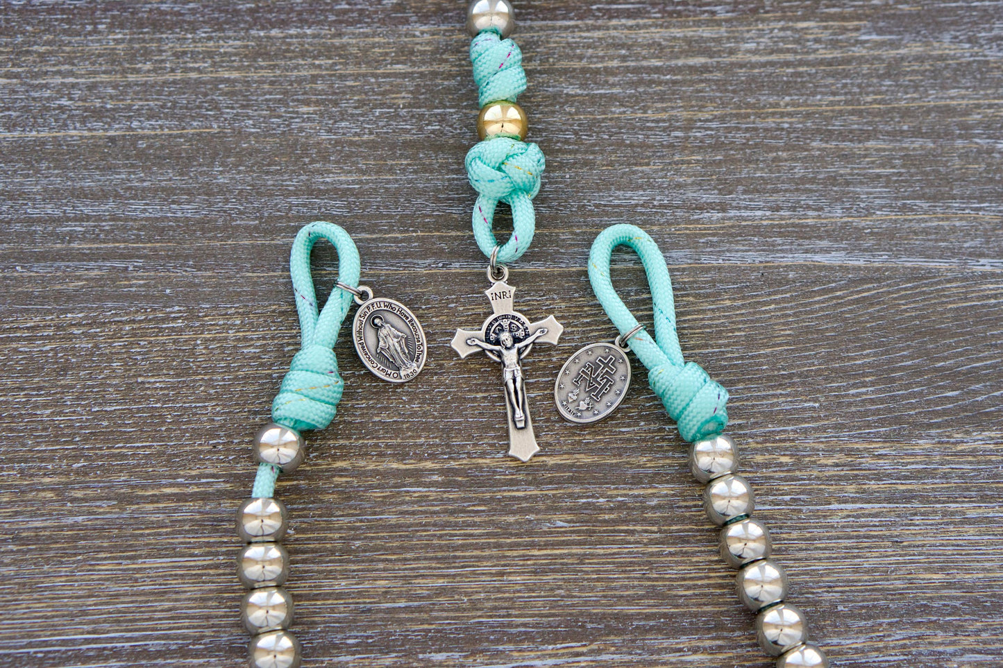 August Queen of Heavens Kids Pocket Paracord Rosary - Featuring 10mm acrylic beads, silver Hail Marys, a rose gold Our Father bead, a petite St. Benedict crucifix, and a Miraculous Medal, this compact single-decade rosary is crafted for children's hands