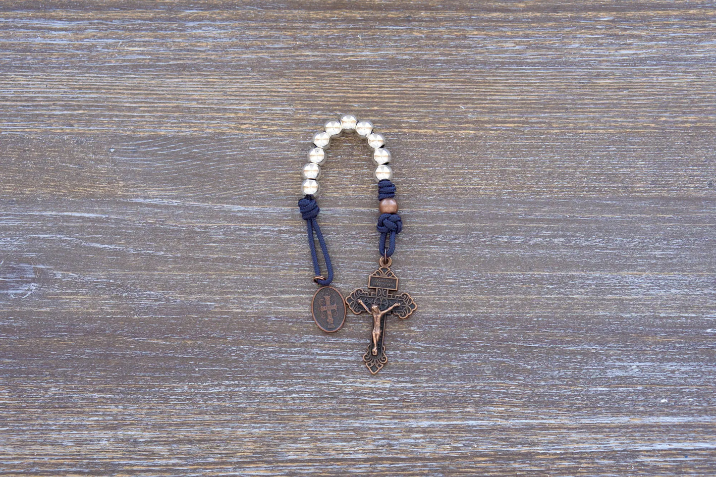 Benedict’s Battle Rosary: compact metal paracord rosary with navy rope, copper accents, and durable, premium finish.