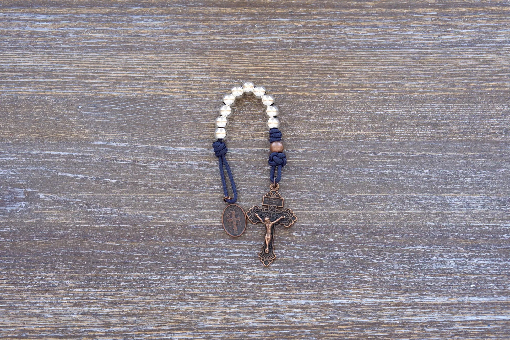 Benedict’s Battle Rosary: compact metal paracord rosary with navy rope, copper accents, and durable, premium finish.