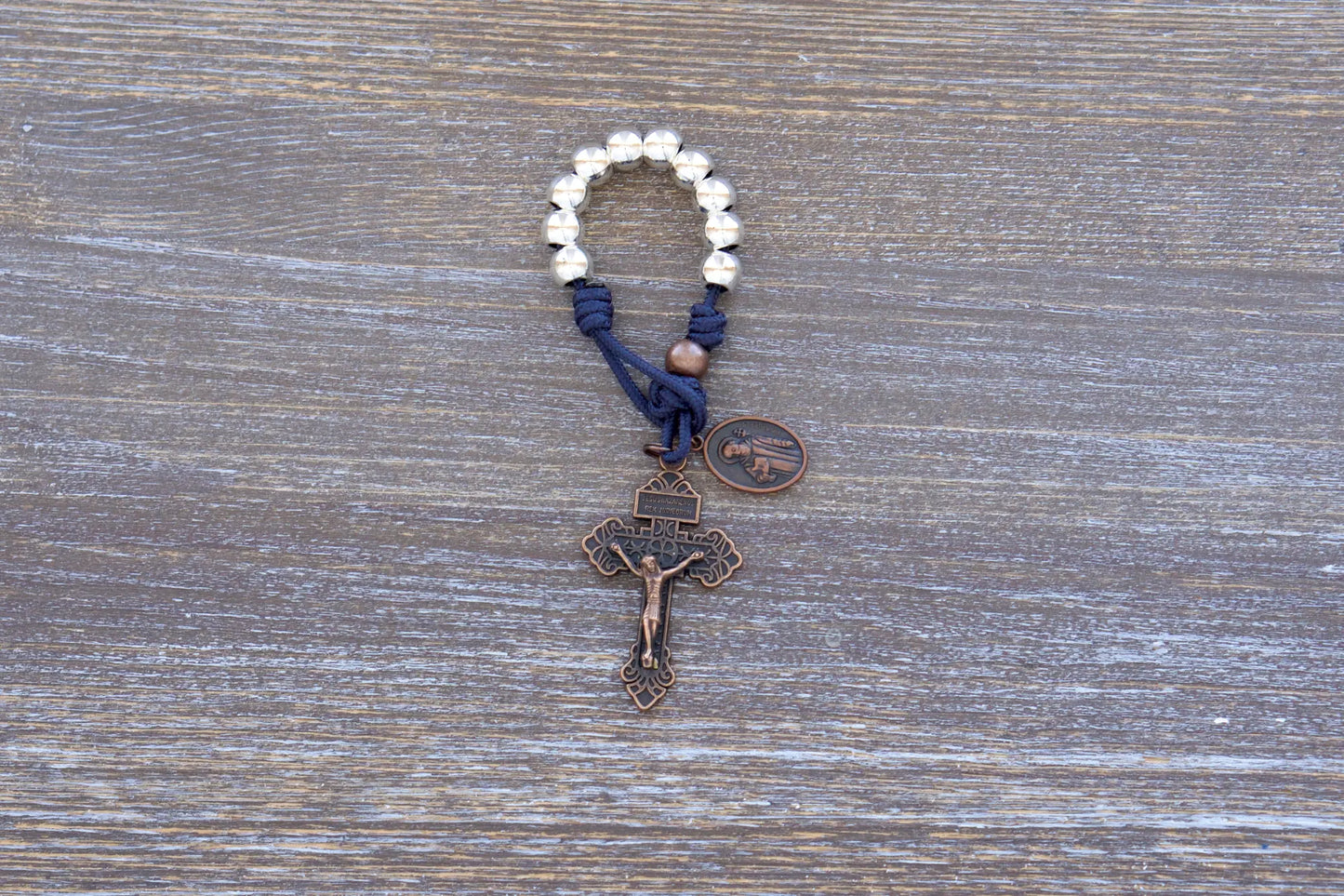 Benedict’s Battle Rosary: premium metal paracord rosary with navy rope, copper accents, and durable, pocket-sized design.
