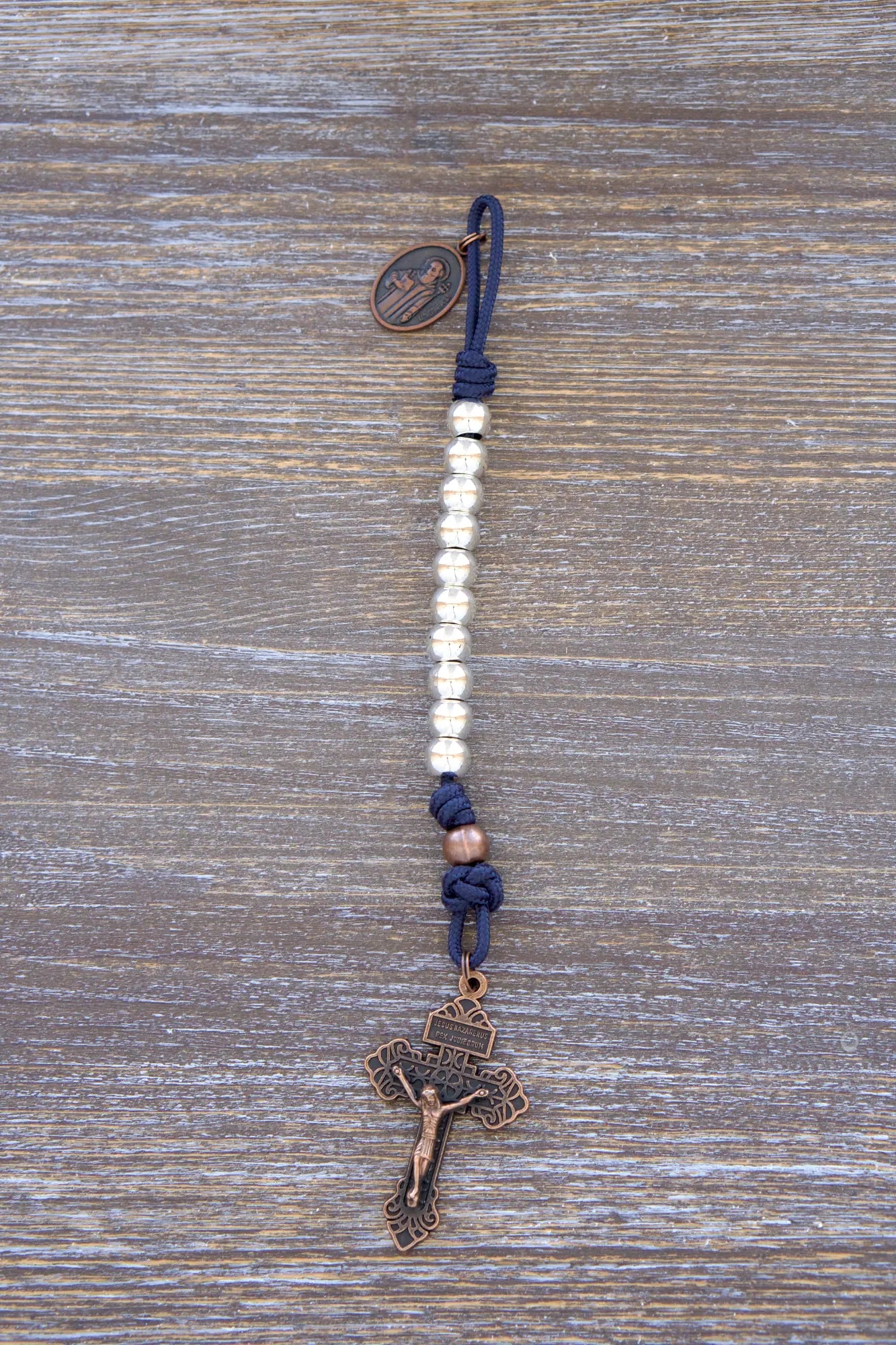 Benedict’s Battle Rosary: compact metal paracord rosary with navy rope, copper accents, and durable, pocket-sized design.