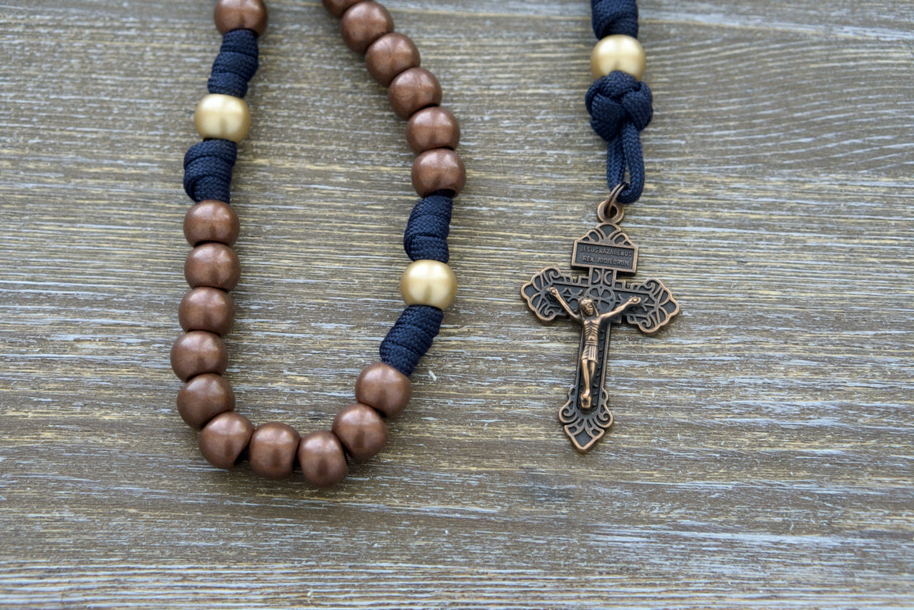 Blessed Be God - 5 Decade Paracord Rosary: Premium quality, unbreakable paracord rosary with antique copper and matte gold beads, navy blue accent rope, Miraculous Medal, and 2-inch copper Pardon Crucifix.