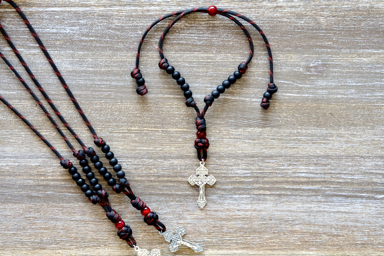 Blood of Christ - Rearview Mirror Rosary, a powerful 9" to 13" paracord rosary for your car's rearview mirror with ten matte black Hail Mary beads, striking red Our Father bead.