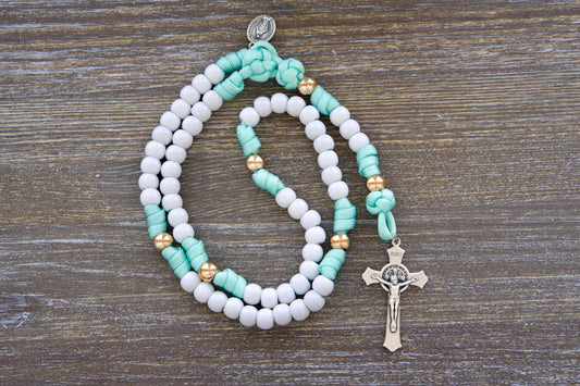 Sturdy mint green and white paracord rosary designed for children, featuring durable 10mm acrylic beads, a smaller Miraculous Medal, and a 2-inch St. Benedict crucifix.