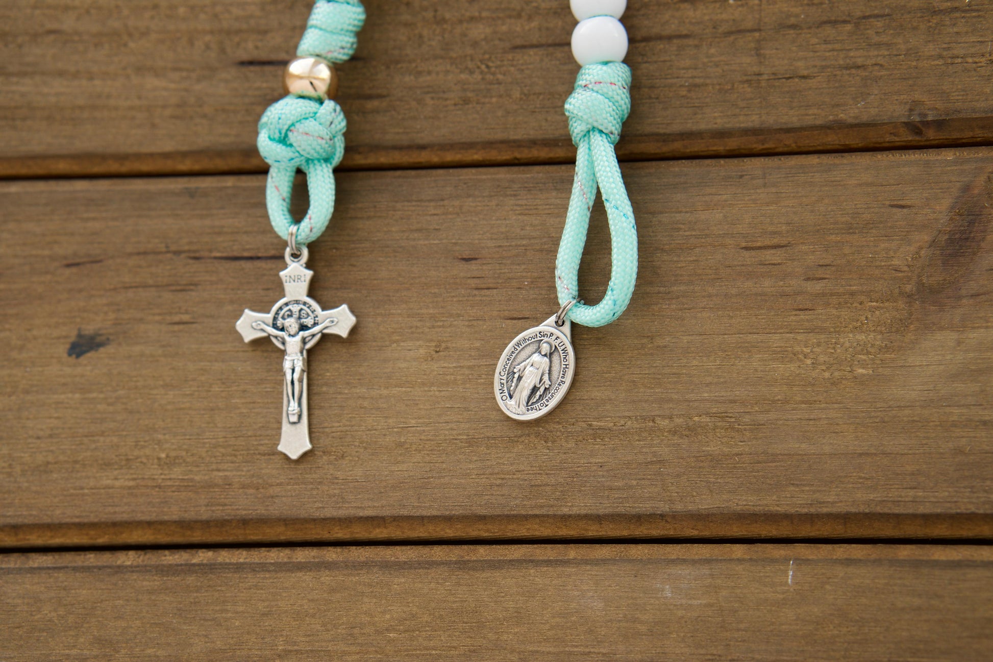 Kid's mint green paracord pocket rosary with white Hail Mary and rose gold Our Father beads, featuring a smaller St. Benedict Crucifix and Miraculous Medal. Perfect for First Communion or Easter gifts for children.