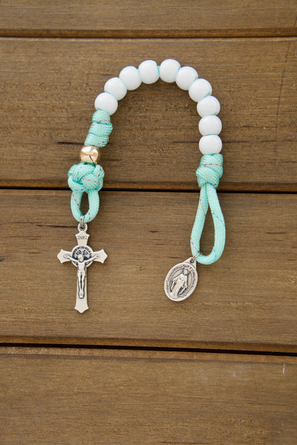 Kid's mint green pocket paracord rosary with white Hail Mary beads, rose gold Our Father beads, St. Benedict Crucifix, and Miraculous Medal - a perfect First Communion or Easter gift for children learning to pray.