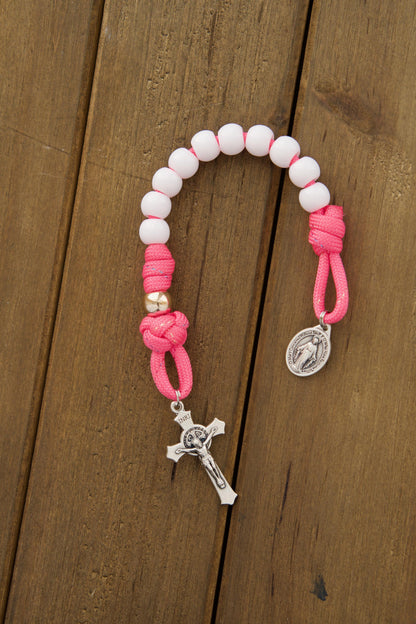  A children's pink and white pocket paracord rosary with durable paracord 550, smaller 10mm beads in white Hail Mary and rose gold Our Father colors, perfect for kids learning to pray.