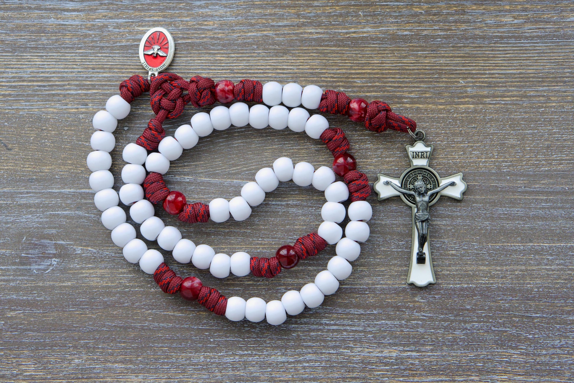 Crimson Shield - Holy Spirit Confirmation Rosary: A handmade 5-decade paracord rosary in maroon red with black or white Hail Mary beads, featuring a gleaming black (or white) enamel St. Benedict crucifix and a vibrant red Holy Spirit medal.