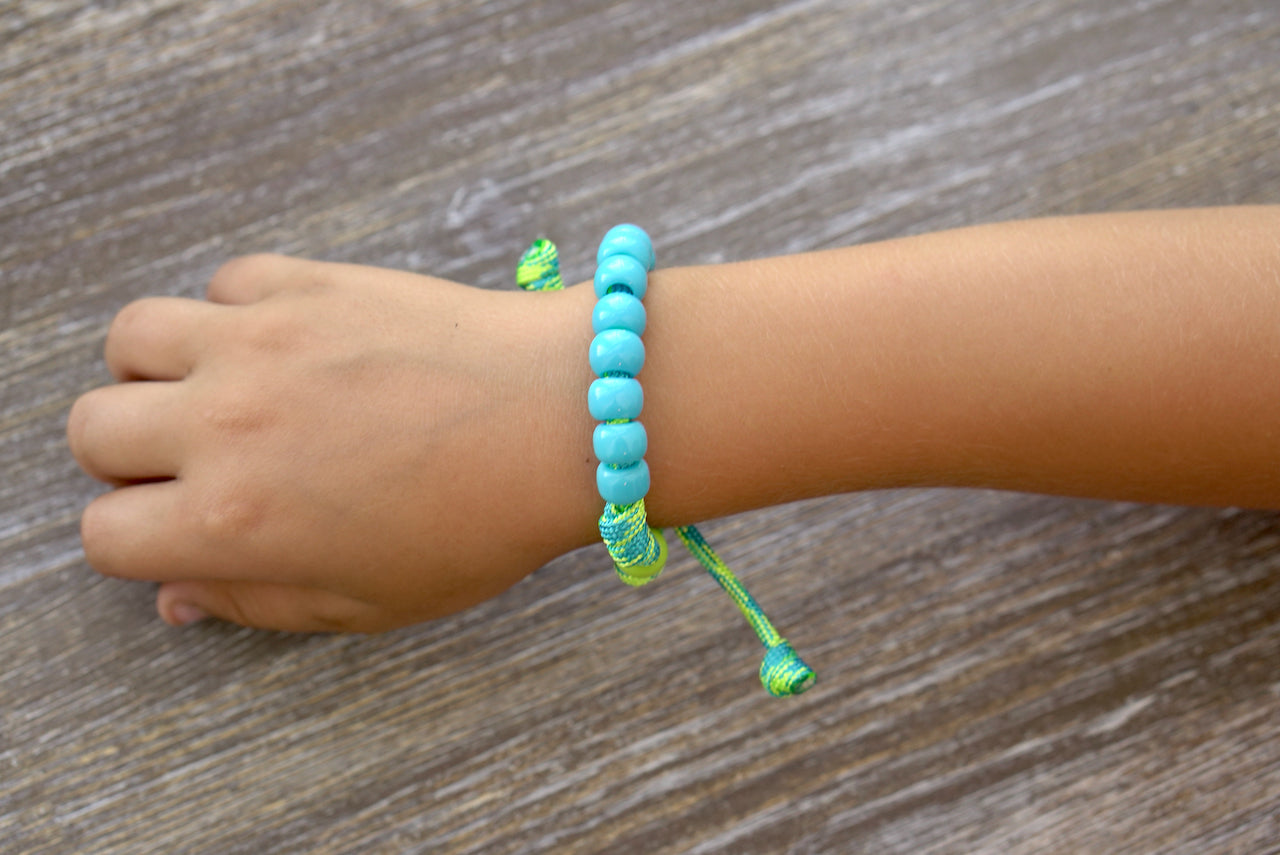 David's Slingshot - Kid's Rosary Bracelet, featuring vibrant lime green and sky blue paracord with matching blue Hail Mary and Our Father beads, petite Miraculous Medal, perfect for young Catholics.