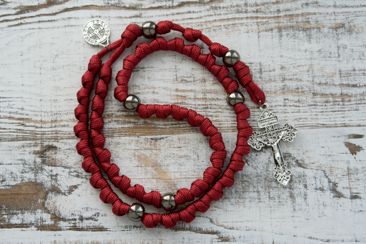 Embrace strength in faith with our new Defender of Faith - Maroon and Gunmetal Knotted Rope Rosary! Crafted from premium paracord, this unbreakable Catholic gift ensures durability during life's battles, featuring St. Benedict devotional medal and a standard 2" Pardon Crucifix.