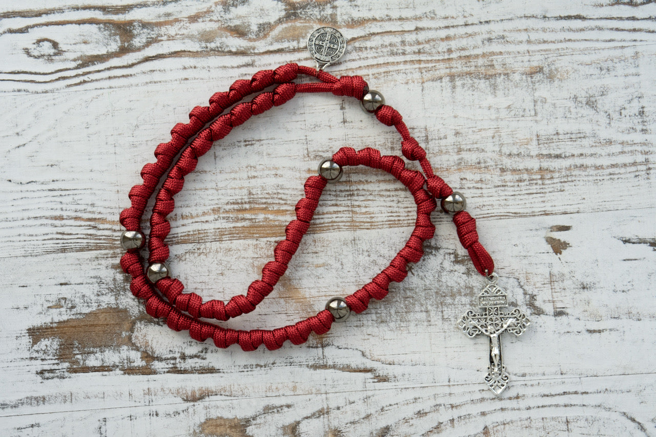 Experience unwavering faith with The Defender of Faith - Maroon and Gunmetal Knotted Rope Rosary, featuring St. Benedict's Devotional Medal. This premium, durable paracord rosary boasts a 2" Pardon Crucifix, acrylic beads.