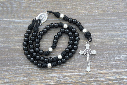Premium metal alloy Hail Mary beads and silver Our Father beads on sturdy black paracord rosary, accented by a silver St. Benedict crucifix.