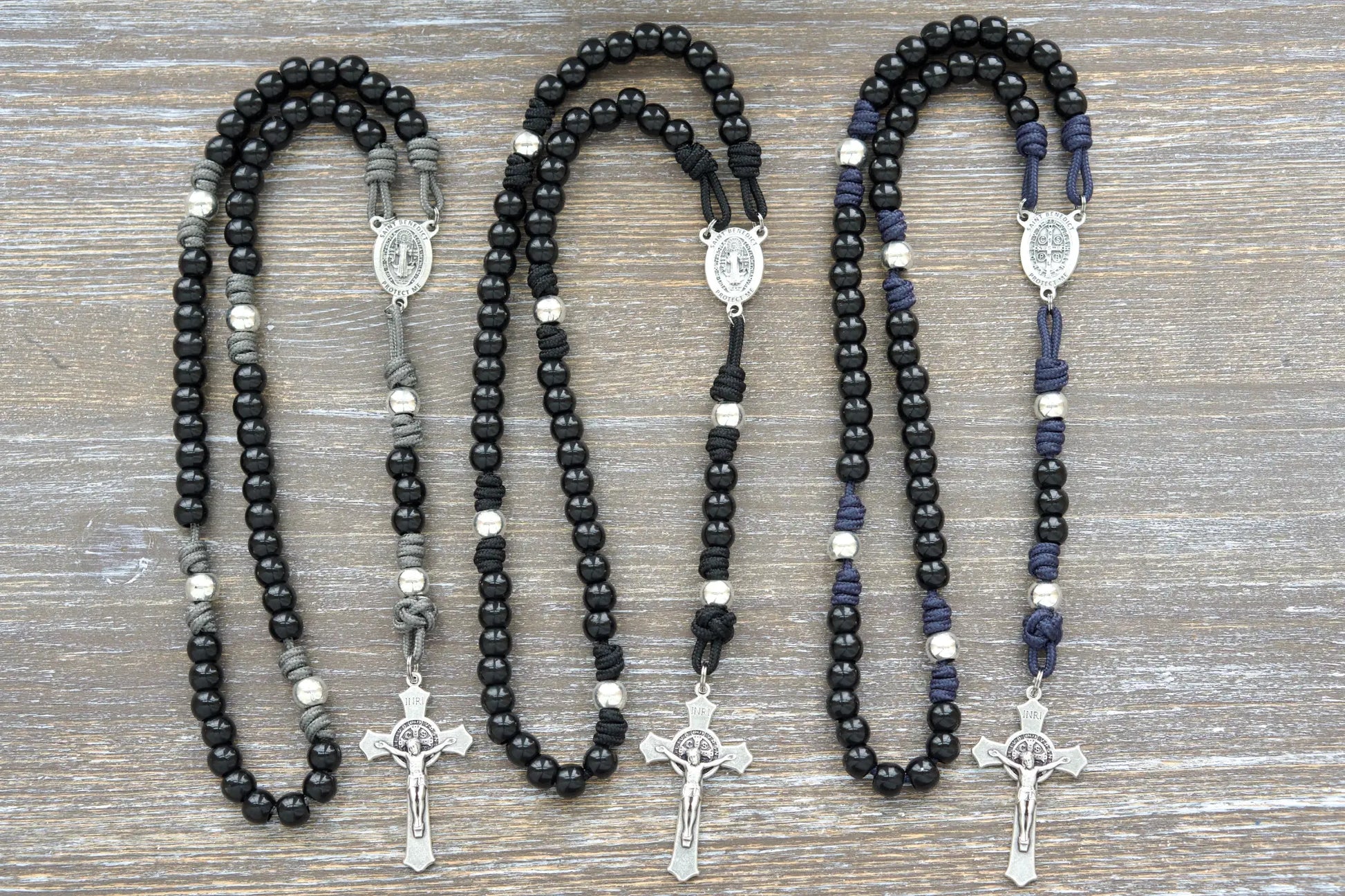 Three black beaded rosaries with silver Benedict Crucifix and centerpiece, available in three colors.