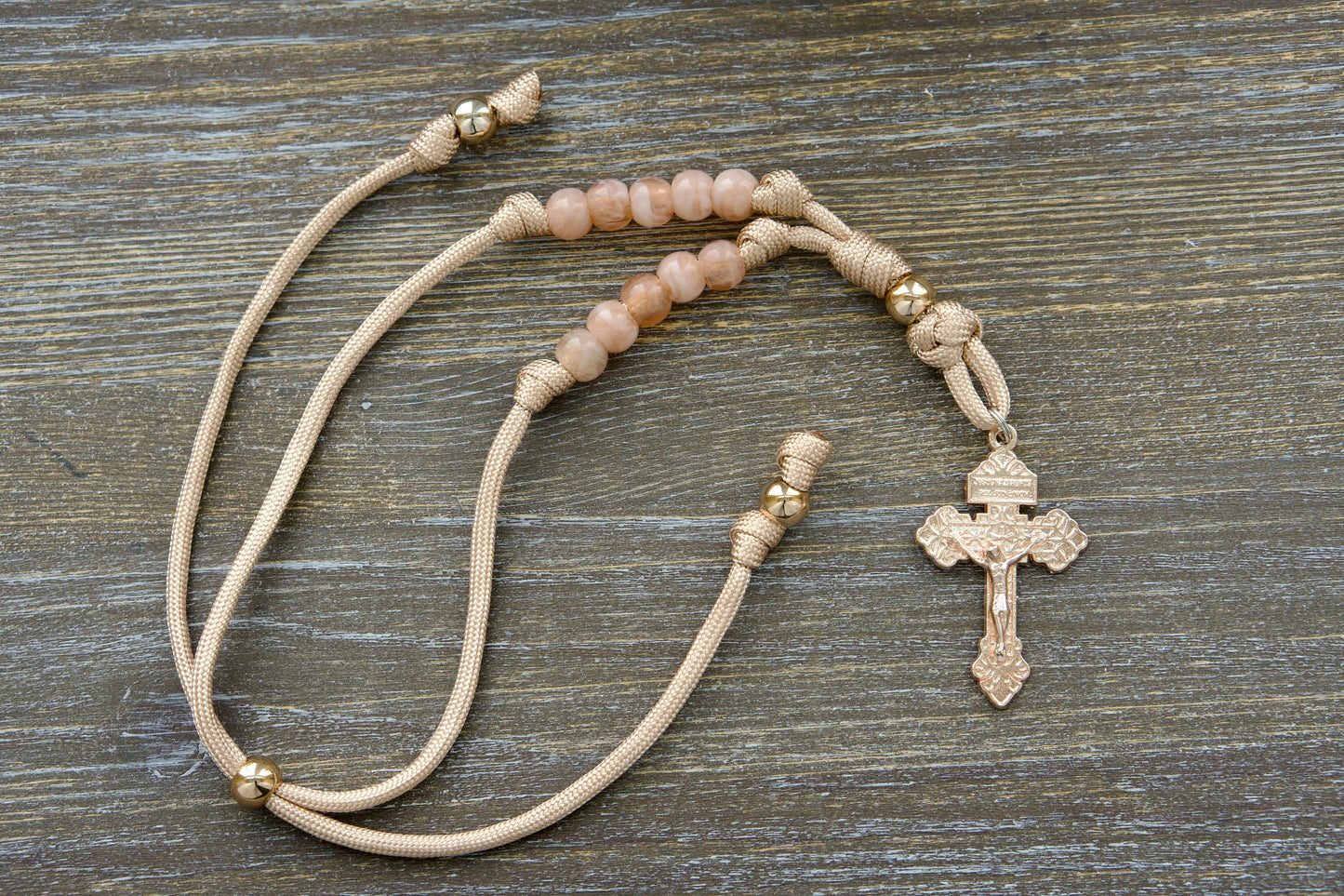 Gate of Heaven Rearview Mirror Rosary: A handmade paracord rosary with rose gold accents and milky pink beads, featuring a unique pardon crucifix centerpiece. Designed for car use.