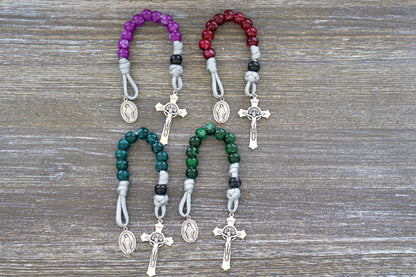 Gemstone Colored - 1 Decade Paracord Rosary, available in four beautiful colors - Garnet Red, Emerald Green, Ingolite Blue, and Magenta. Handcrafted with paracord 550, 12mm acrylic beads, Miraculous Medal devotional medal, and a 2-inch St. Benedict Crucifix for added spiritual strength.