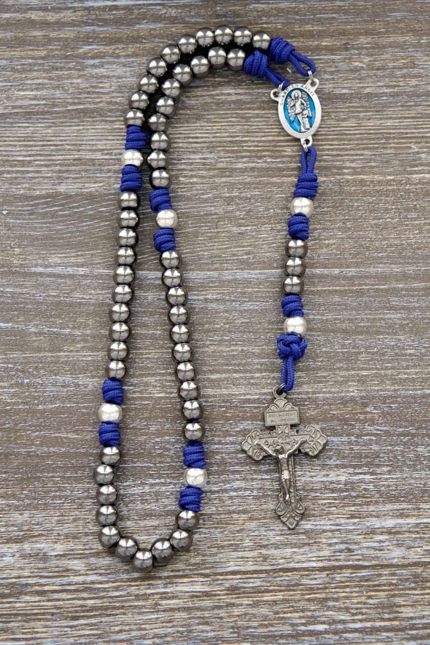 Guardian of Grace: Royal Blue, Gunmetal, and Silver Guardian Angel Paracord Rosary. Durable paracord rosary featuring stunning royal blue 275 paracord, premium metal alloy beads, and a beautiful blue enamel Guardian Angel centerpiece.